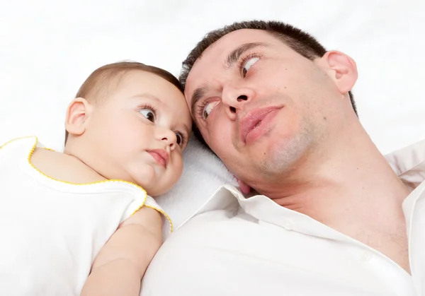 Gelukkige familie, vader en baby op het witte bed — Stockfoto
