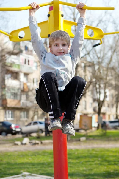 The small child hanging on a horizontal bar — Stock Photo, Image