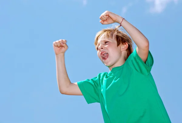Счастливый мальчик-футбольный болельщик на фоне неба — стоковое фото
