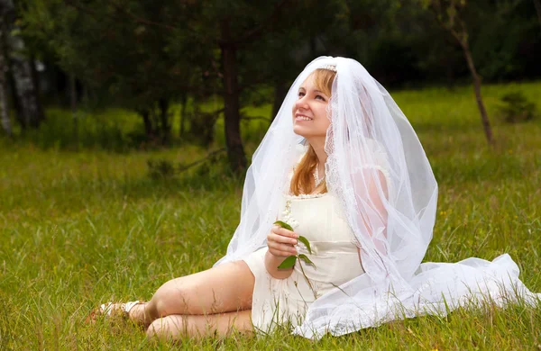 Gelukkig meisje in trouwjurk in park — Stockfoto