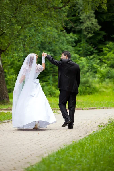 Düğün çifti bir parkta güneşli bir günde dans. — Stok fotoğraf