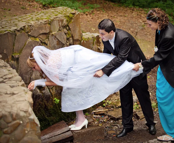 Nygifta dricka vatten från en källa i skogen — Stockfoto
