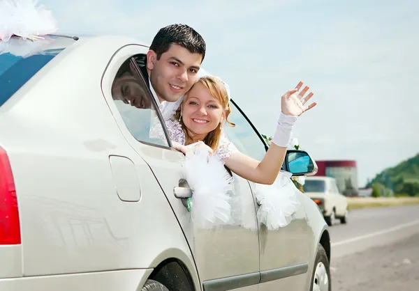 Verheugd huwelijksfeest paar in auto — Stockfoto