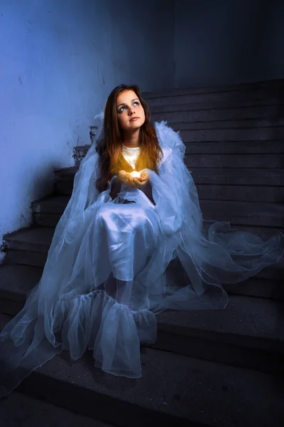 Anjo com uma vela sentada nas escadas — Fotografia de Stock