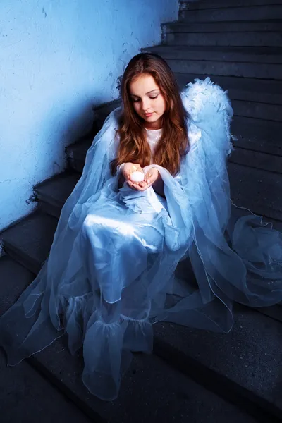 Portret van een engel met een kaars zittend op de trap — Stockfoto