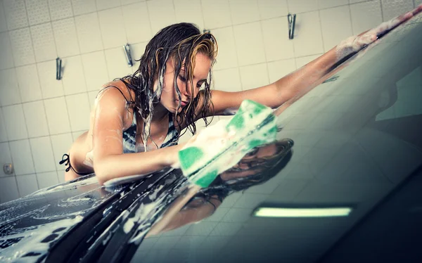 Model op het wassen van de auto in de garage. — Stockfoto