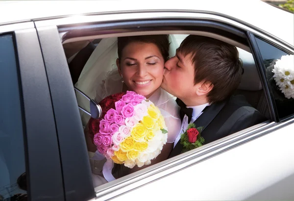 Closeup of newlywed couple kissing in wedding car — Stock Photo, Image