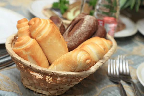 Closeup chleba rohlíky v koši na restauraci u stolu. Royalty Free Stock Obrázky