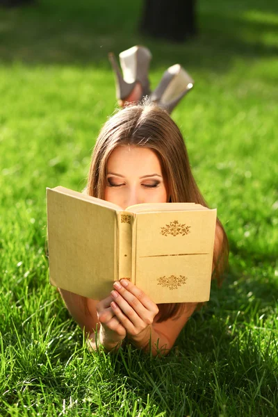 Женщина в парке с книгой — стоковое фото