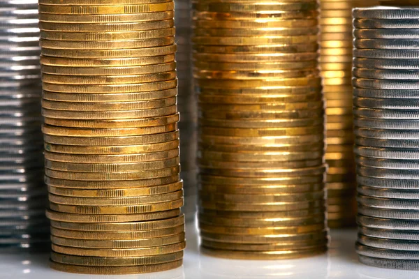 Zlaté a stříbrné mince hromádky — Stock fotografie