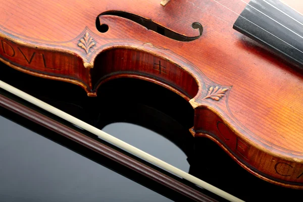 Violin och rosett på mörk bakgrund — Stockfoto