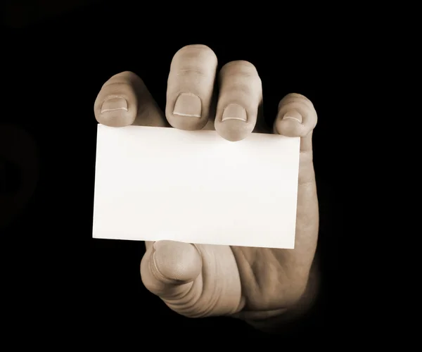 Mão com cartão de visita preto no fundo preto — Fotografia de Stock