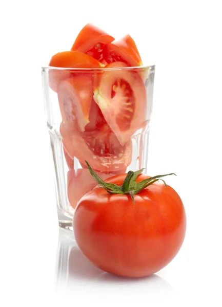 Tomate e fatias em vidro isolado sobre fundo branco — Fotografia de Stock