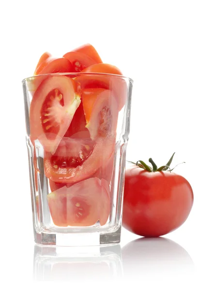 Tomaat en tomaat segmenten in glas geïsoleerd op witte achtergrond — Stockfoto