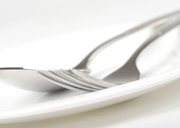 Фото вилки и ложки на тарелке — стоковое фото