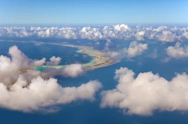 Polynésie. atol ring v oceánu je viditelný skrz mraky. Letecký pohled — Stock fotografie