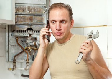 The man calls by phone to cause the repairman of gas water heaters clipart