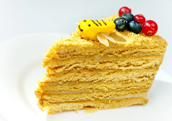 Pedaço do bolo de mel decorado com uma abelha de esmalte — Fotografia de Stock