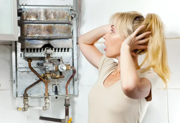 Mladá žena je rozrušený tím, že má zlomený plynový ohřívač vody — Stock fotografie