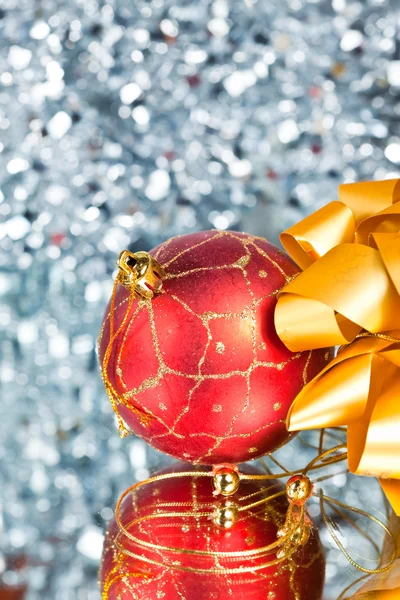 Roter Neujahrsball und goldene Schleife auf abstraktem silbrigem Hintergrund — Stockfoto