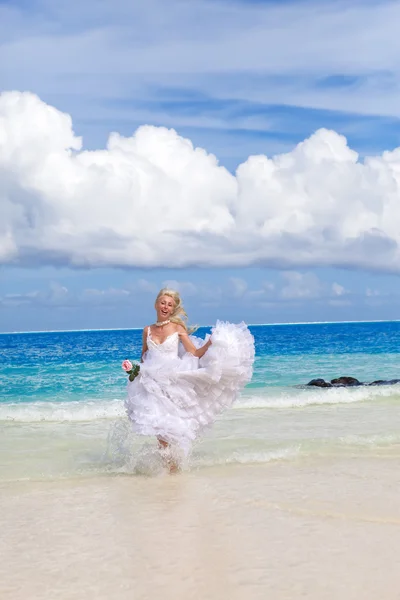 Den unga vackra kvinnan i en klänning bruden går på havets vågor — Stockfoto