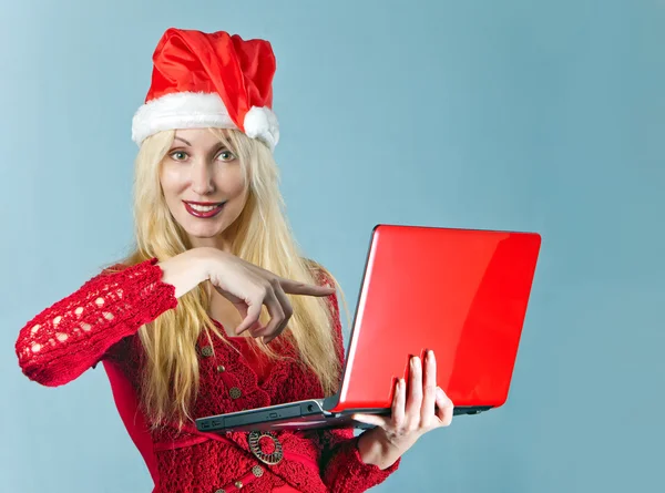 The blonde in a New Year's hat and with the red laptop — Stock Photo, Image