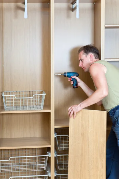 stock image The man is engaged in repair and furniture assemblage