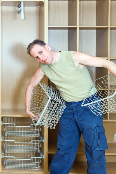 Чоловік встановлює кошики в новому гардеробі — стокове фото