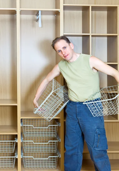 Mannen upprättar korgar i en ny garderob — Stockfoto