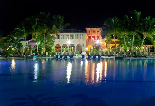 Edifícios com iluminação noturna atrás da piscina — Fotografia de Stock
