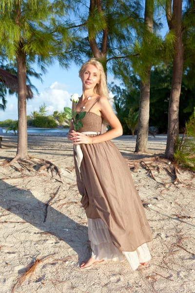 Den unga kvinnan i en lång sundress på en tropisk strand. Polynesien. ö t — Stockfoto