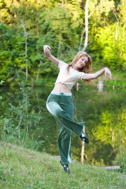 Young woman is engaged in sport on coast of pond