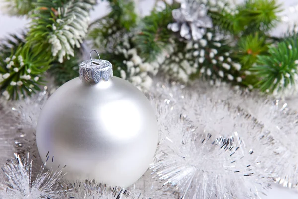 Bola de Año Nuevo y ramas cubiertas de nieve de un árbol de Navidad — Foto de Stock