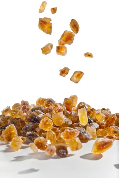 Slices of falling brown candy sugar — Stock Photo, Image