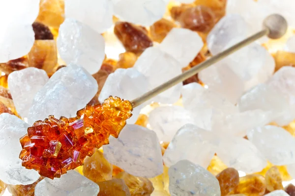 Цукерки коричневий цукор на паличці лежить на білому цукрі — стокове фото