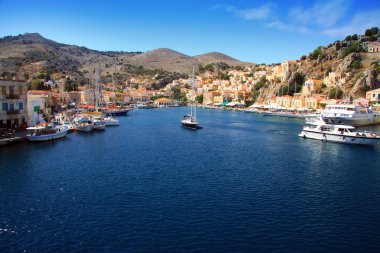 Small boats and houses on symi island, Greece clipart