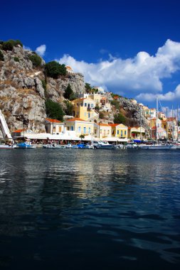 Greece. Dodecanesse. Island Symi (Simi). Colorful houses on rocks. clipart