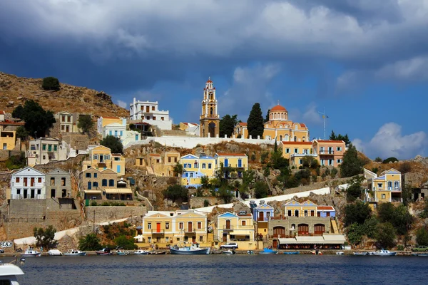 Grekland. dodecanesse. ön symi (simi). färgglada hus på stenar. — Stockfoto