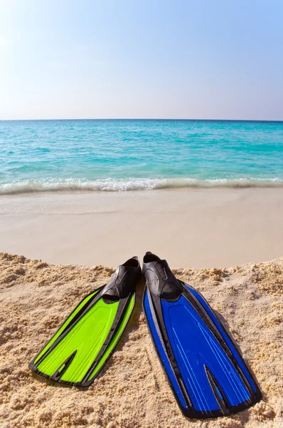 Verschillende kleuren flippers op zand aan zee rand — Stockfoto