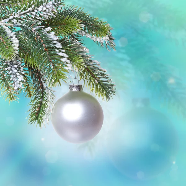 La palla di anno nuovo di vetro e i rami coperti dalla neve di un albero di Natale — Foto Stock