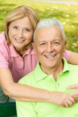 Happy mature woman embracing elderly man clipart