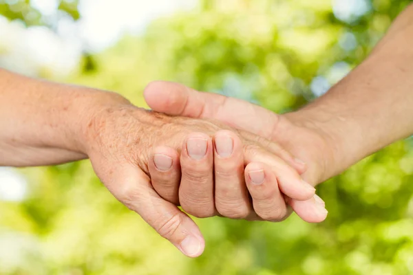 Closeup of old hands holding together outdoor — Stock Photo, Image