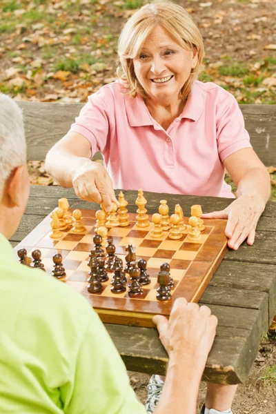 Satranç oynayan bir bankta kıdemli mutlu çift — Stok fotoğraf