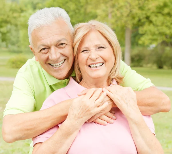 Happy elderly man embracing mature woman — Stock Photo, Image