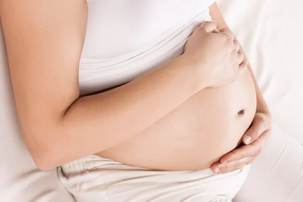 Zwangere vrouw houdt haar buik vast — Stockfoto