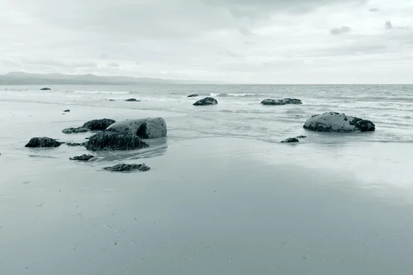 Azul tonificado tranquila escena en la playa de Criccieth — Foto de Stock