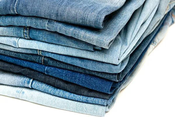 Pilha de jeans azuis no fundo branco — Fotografia de Stock