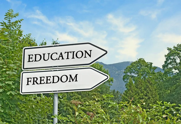Дорожный знак к образованию и свободе — стоковое фото