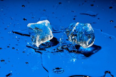 Mavi yüzeye düşen buz küpleri