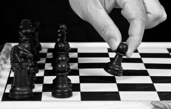 Elle oynama ile siyah satranç taşları — Stok fotoğraf